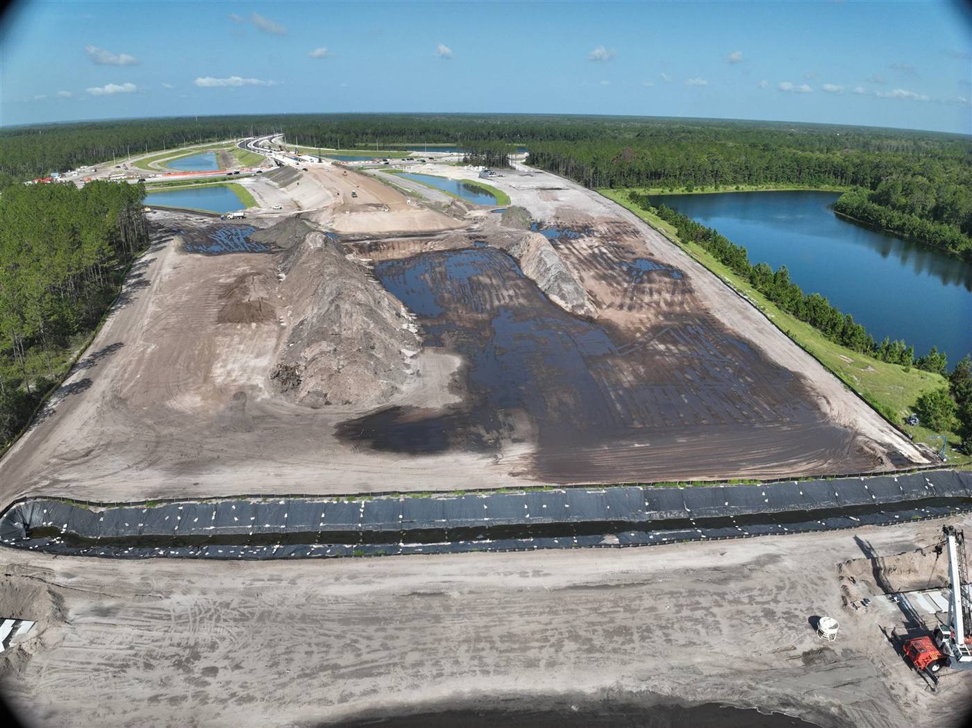Aerial of a graded site with pond