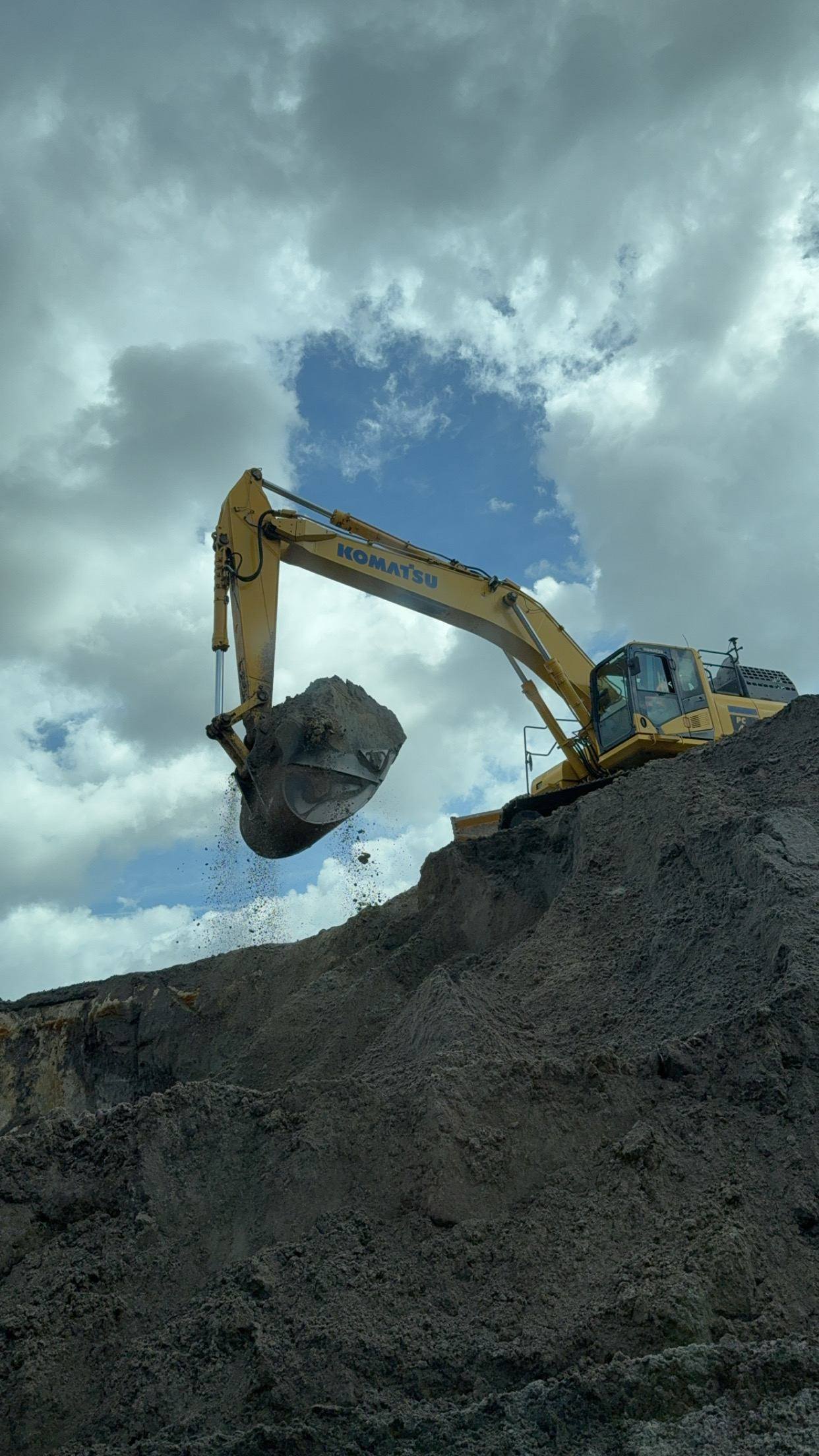 Excavator working a material stockpile
